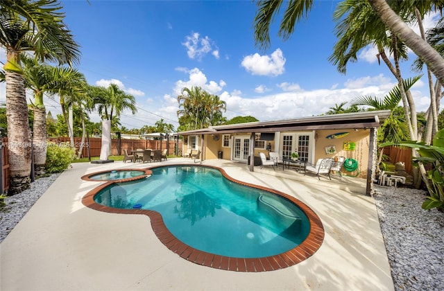 view of pool featuring an in ground hot tub, a patio, and french doors