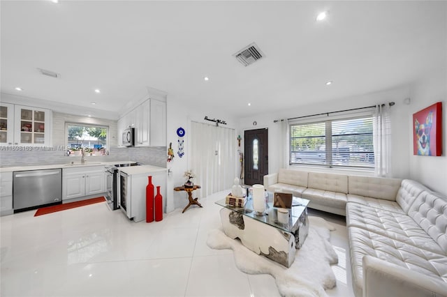 living room featuring sink and light tile patterned floors