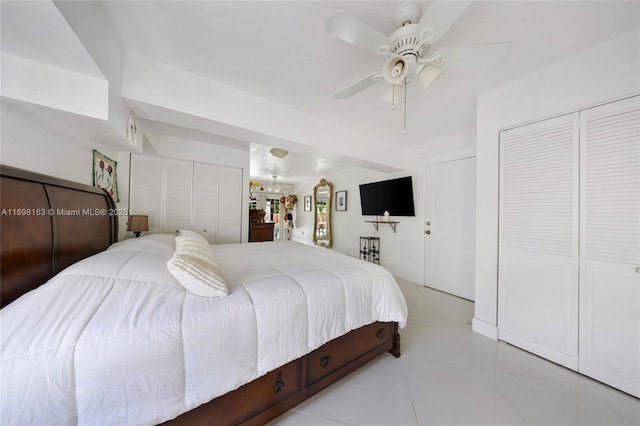 tiled bedroom featuring ceiling fan and two closets