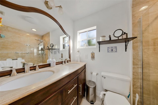 bathroom with toilet, vanity, and tiled shower