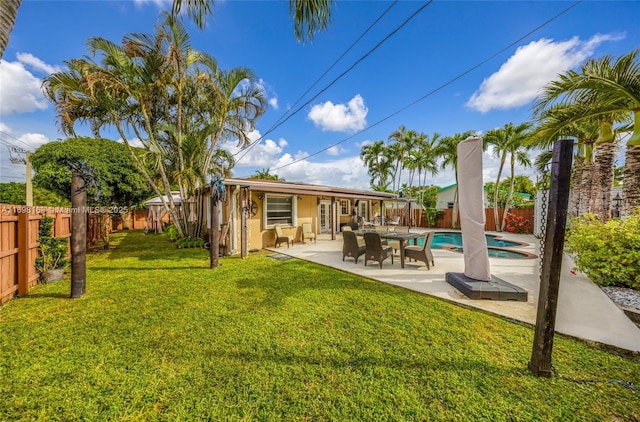 back of house featuring a patio area, a fenced in pool, a yard, and french doors