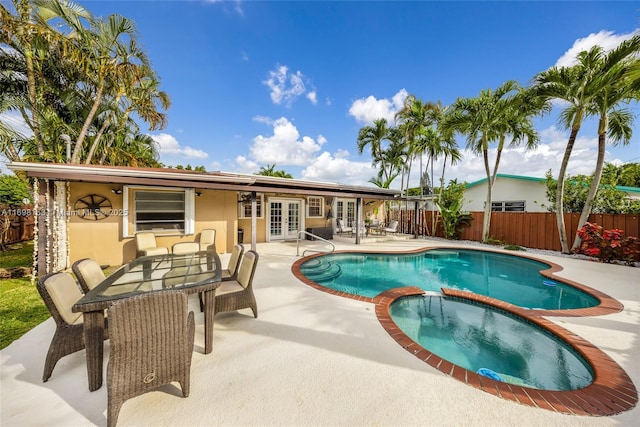 view of swimming pool with an in ground hot tub, a patio, and french doors