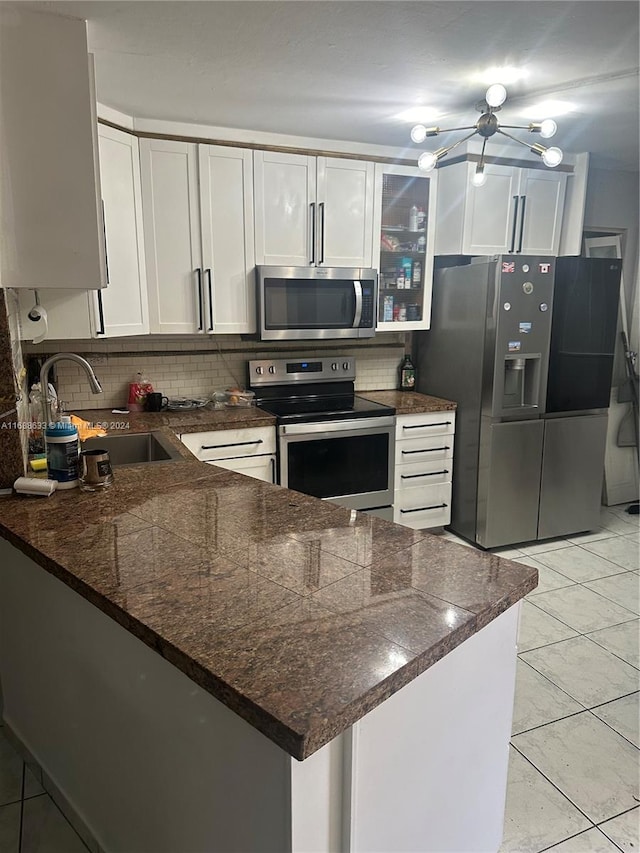 kitchen featuring white cabinets, kitchen peninsula, and appliances with stainless steel finishes