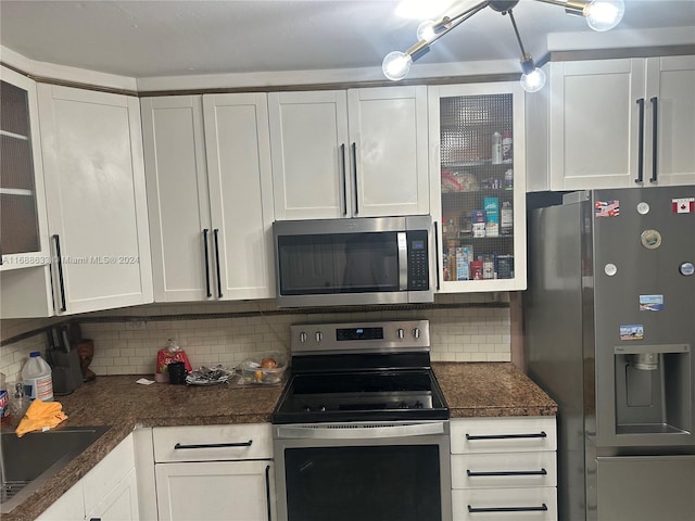 kitchen with backsplash, white cabinetry, and stainless steel appliances