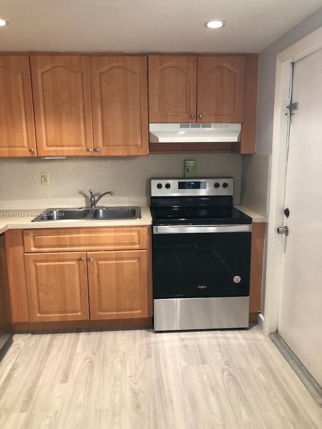 kitchen with sink, light wood-type flooring, and stainless steel range with electric cooktop