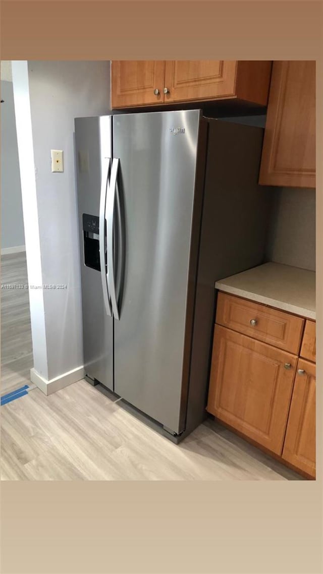 kitchen featuring stainless steel fridge and light hardwood / wood-style floors