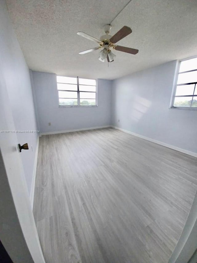 unfurnished room featuring ceiling fan, wood-type flooring, and a textured ceiling