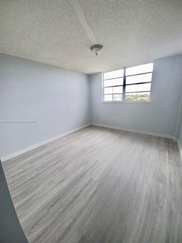 spare room with wood-type flooring and a textured ceiling