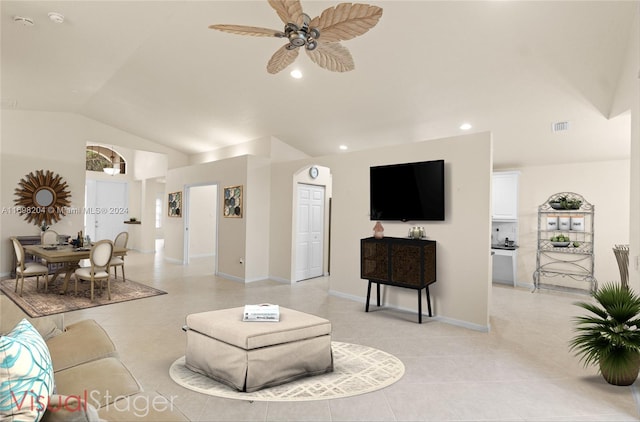 tiled living room with ceiling fan and vaulted ceiling