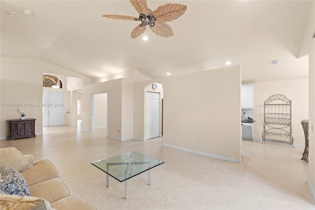 living room featuring ceiling fan, light tile patterned flooring, and vaulted ceiling