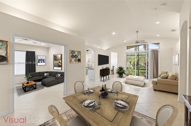 tiled dining space with ceiling fan and lofted ceiling