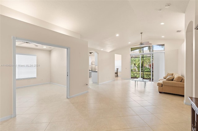 living room featuring ceiling fan, light tile patterned floors, and vaulted ceiling