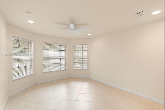 tiled spare room featuring ceiling fan and plenty of natural light