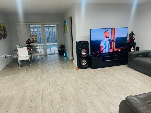 living room with french doors and light wood-type flooring