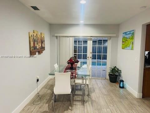 dining space with french doors and light hardwood / wood-style floors