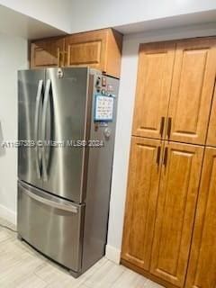 kitchen featuring stainless steel refrigerator and light hardwood / wood-style flooring