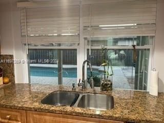 kitchen featuring stone counters and sink