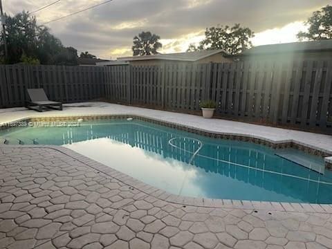 pool at dusk with a patio