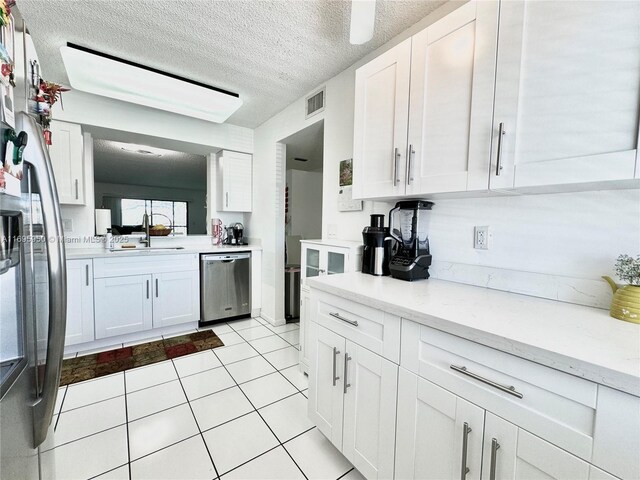 kitchen featuring light stone countertops, sink, white cabinetry, and stainless steel appliances