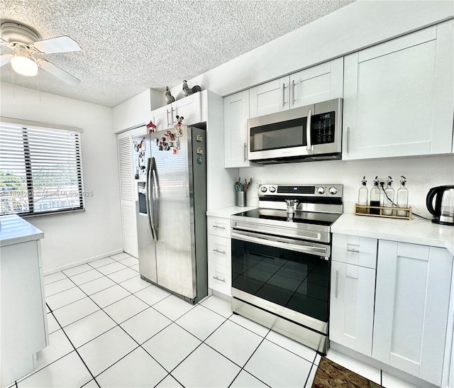 kitchen with a textured ceiling, ceiling fan, appliances with stainless steel finishes, and white cabinets