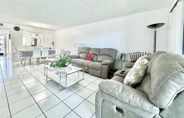 tiled living room featuring a textured ceiling