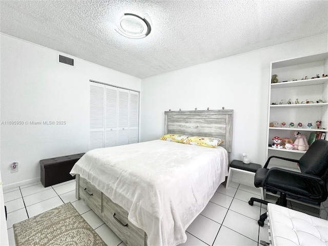 tiled bedroom featuring a textured ceiling and a closet