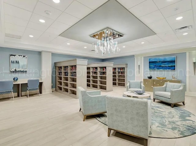 sitting room with baseboards, visible vents, wood finished floors, a tray ceiling, and recessed lighting