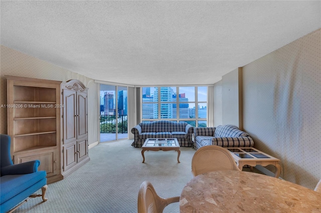 carpeted living room featuring a textured ceiling and floor to ceiling windows