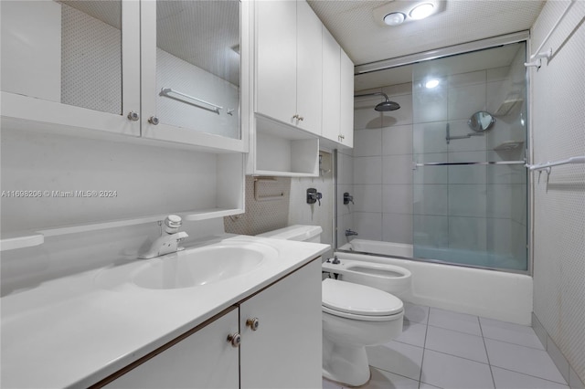 full bathroom with tile patterned floors, a bidet, bath / shower combo with glass door, toilet, and vanity