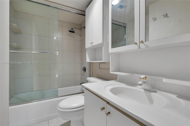 full bathroom featuring vanity, tile patterned floors, toilet, enclosed tub / shower combo, and tile walls