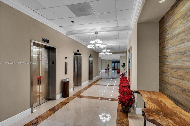 hallway with elevator, ornamental molding, and a notable chandelier