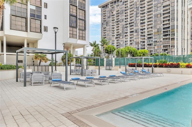 view of pool with outdoor lounge area, a pergola, and a patio