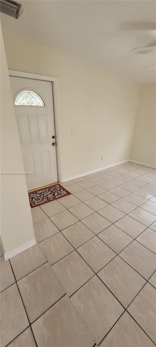 tiled foyer with ceiling fan