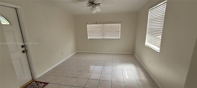 spare room with ceiling fan and light tile patterned flooring