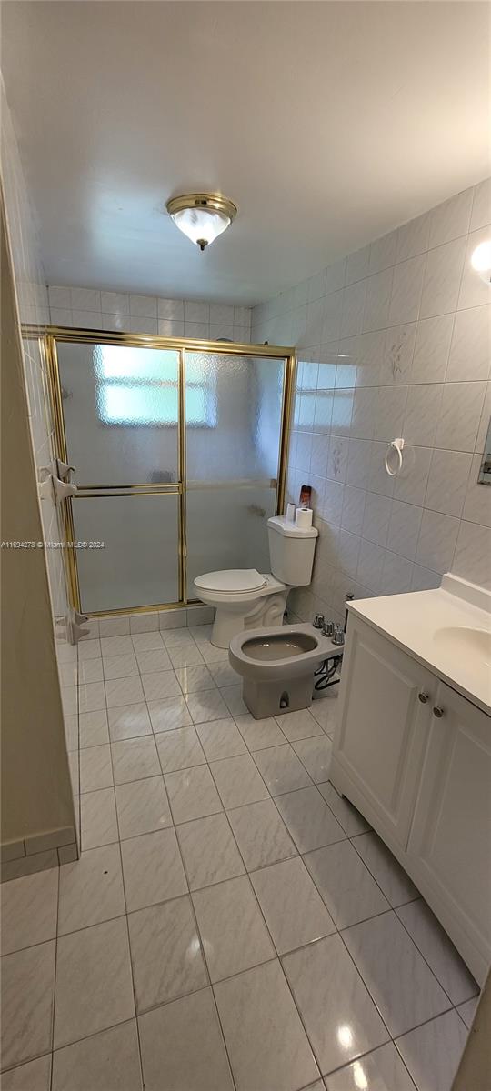 bathroom featuring tile patterned flooring, a bidet, and walk in shower