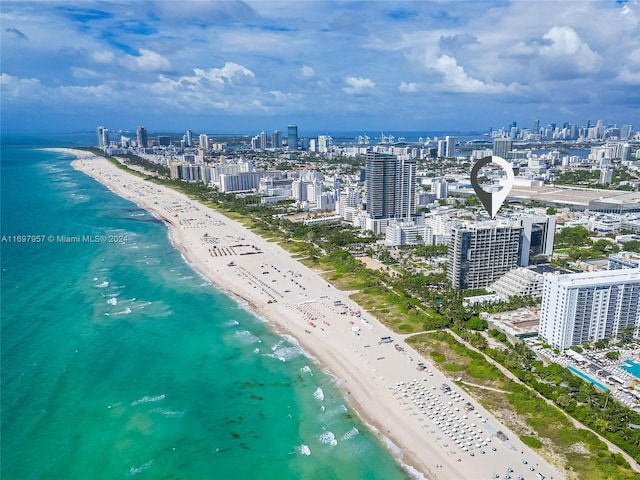 birds eye view of property featuring a water view and a beach view