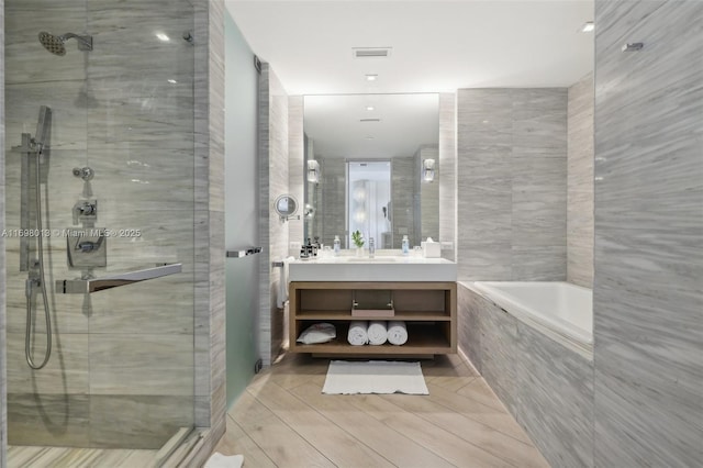 2201 Collins Ave Unit 1015, Miami Beach, FL 33139 - full bathroom with a stall shower, a bath, vanity, and tile walls