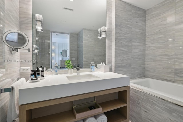 2201 Collins Ave Unit 1015, Miami Beach, FL 33139 - full bathroom featuring tile walls, a bathtub, and vanity