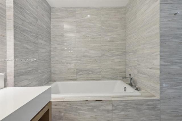 2201 Collins Ave Unit 1015, Miami Beach, FL 33139 - bathroom with a relaxing tiled tub and vanity