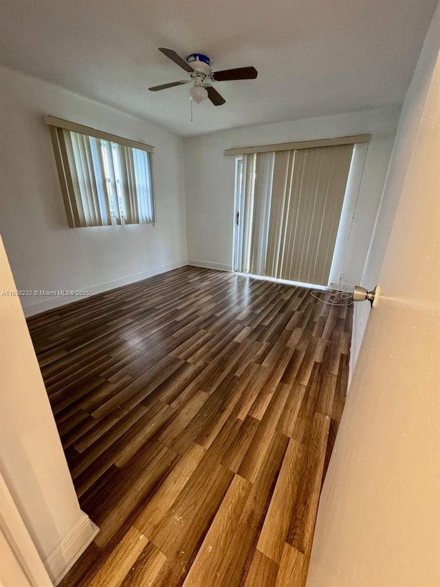 unfurnished room with ceiling fan, baseboards, and wood finished floors