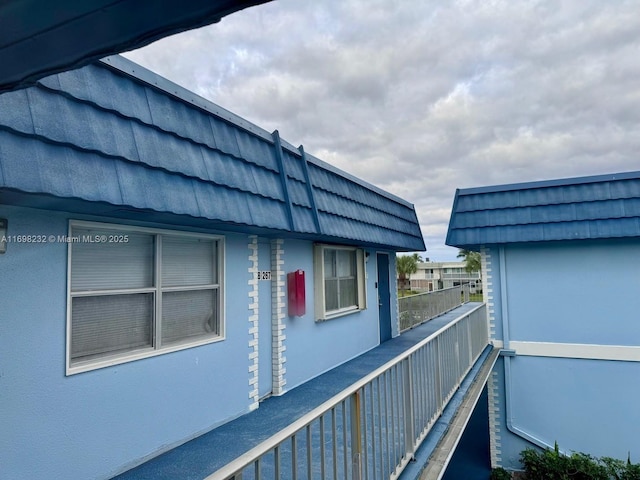 view of side of property featuring mansard roof