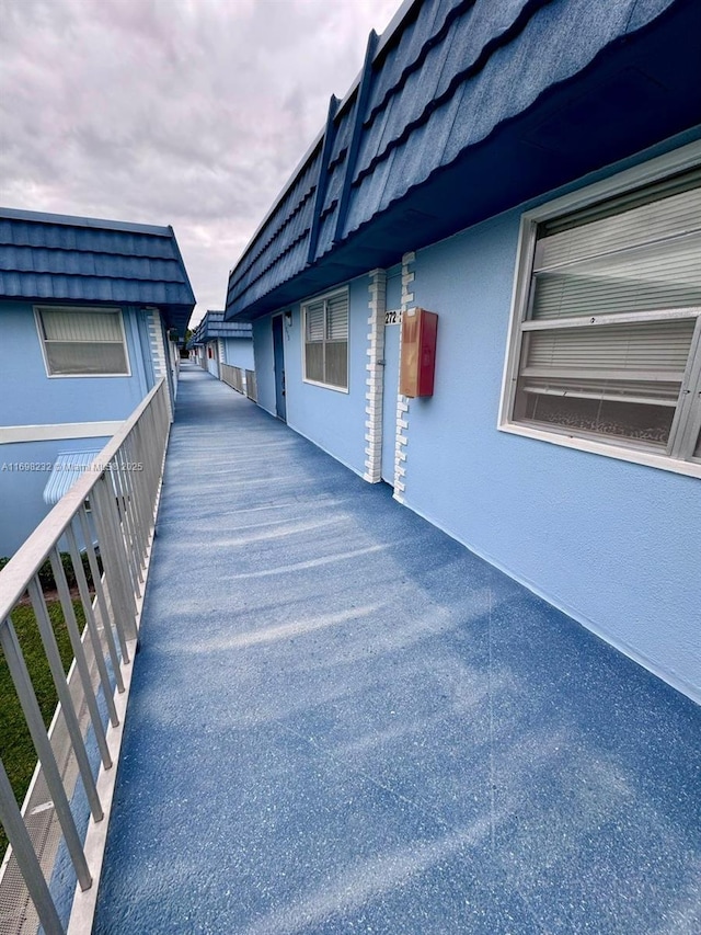 view of property exterior with a tile roof and stucco siding