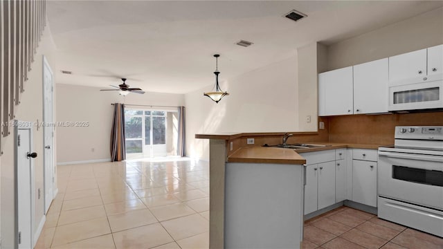 kitchen with white appliances, sink, decorative light fixtures, light tile patterned flooring, and kitchen peninsula