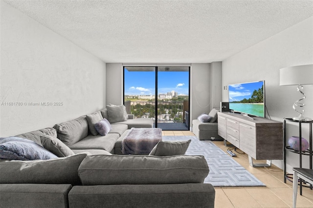 living room featuring light tile patterned floors, a textured ceiling, and expansive windows