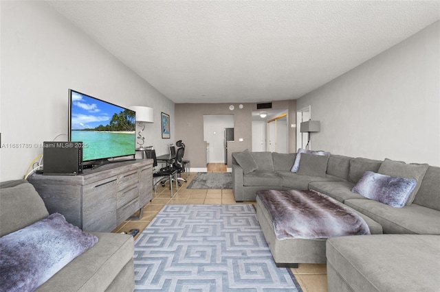 living room featuring visible vents, a textured ceiling, and light tile patterned floors