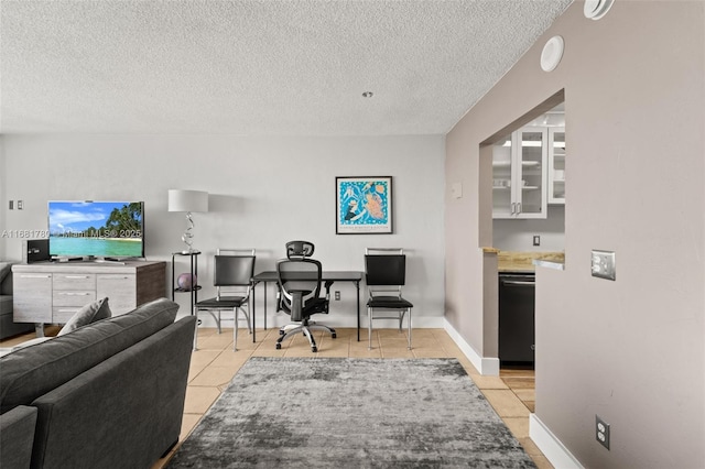 home office with a textured ceiling, baseboards, and light tile patterned floors