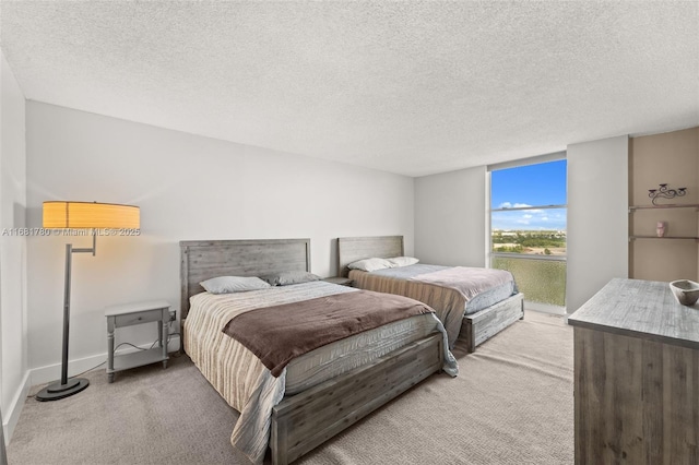bedroom with a textured ceiling, light carpet, and baseboards