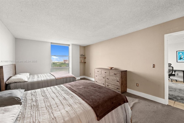 bedroom featuring light carpet, a textured ceiling, and baseboards