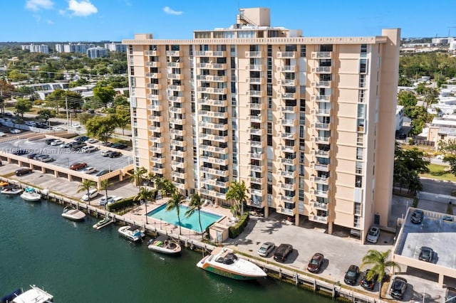 view of building exterior featuring uncovered parking and a water view