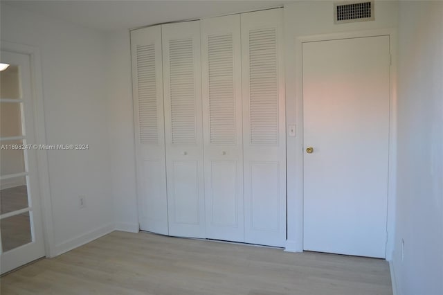 unfurnished bedroom with light hardwood / wood-style flooring and a closet